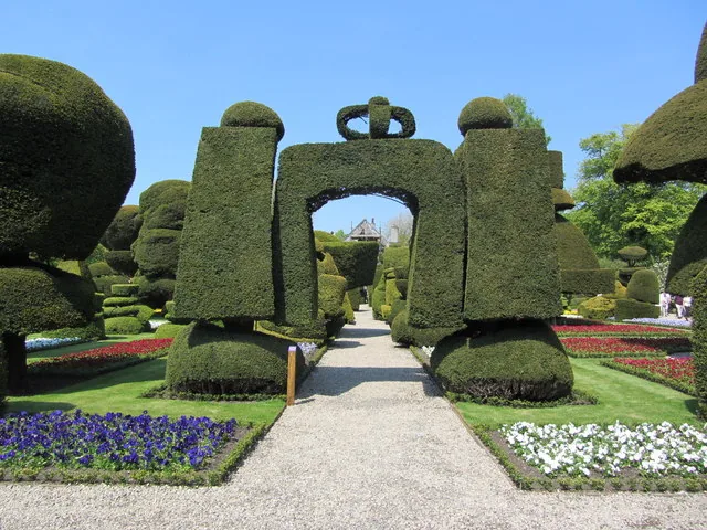 A clipped yew arch crowned with topiary
